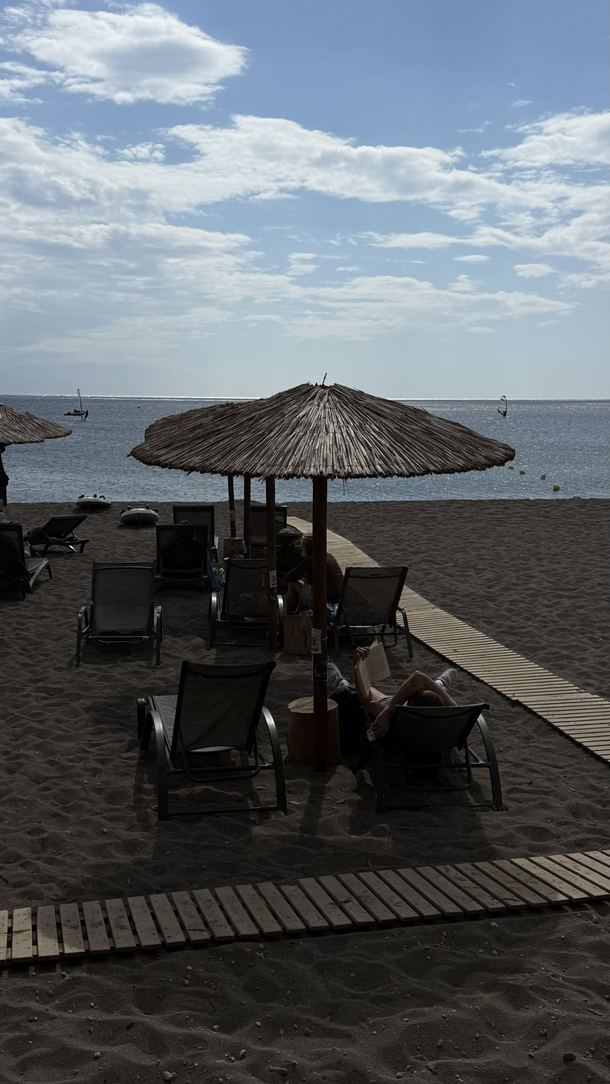 Leżaki i parasole na piaszczystej plaży przy Aeolian Village
